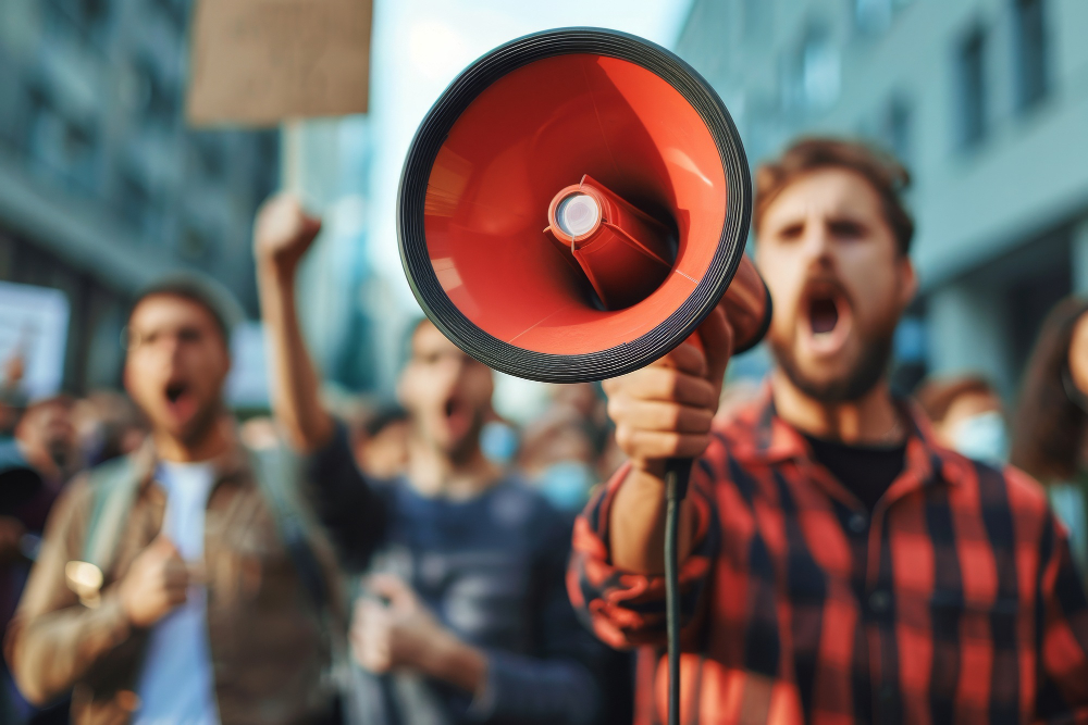 Manifestante segura um megafone vermelho durante um protesto